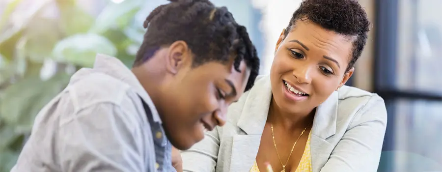 An adult and minor doing work at the table