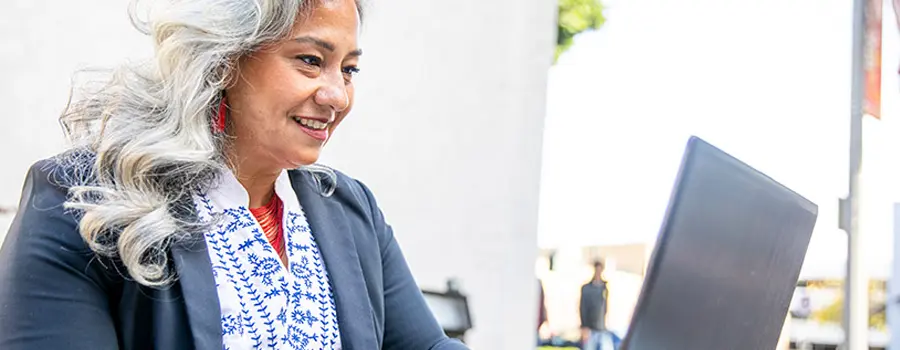 Adult sitting outside using a laptop