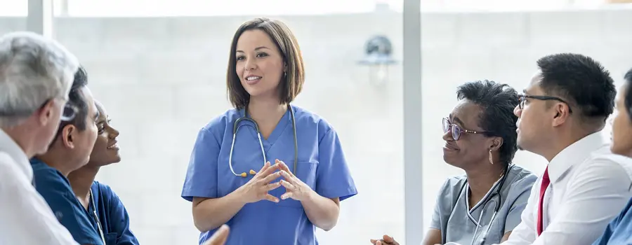 A healthcare professional speaking in front of other healthcare professionals