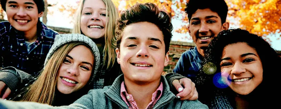 A group of young people sitting and smiling