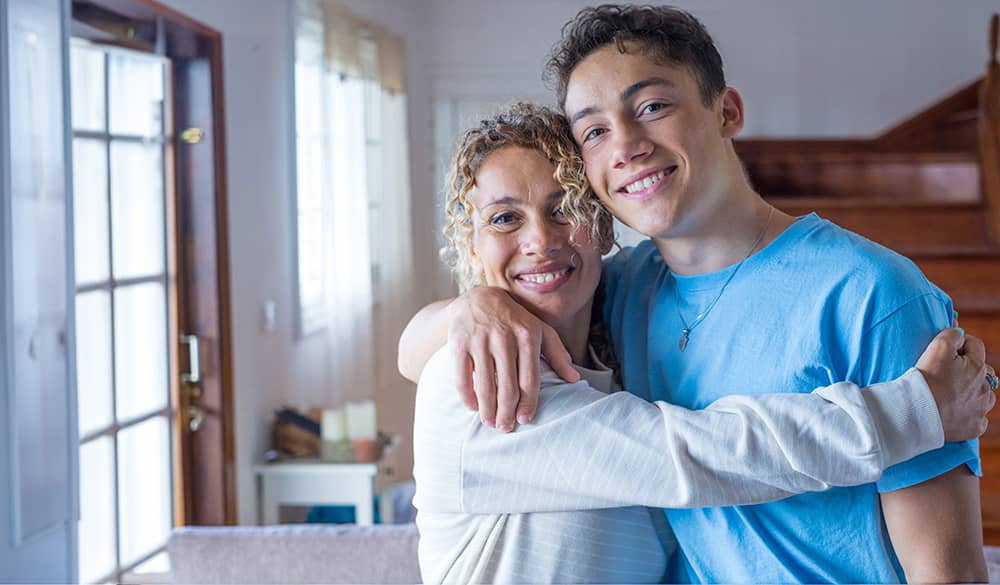 A mother and son hugging and smiling