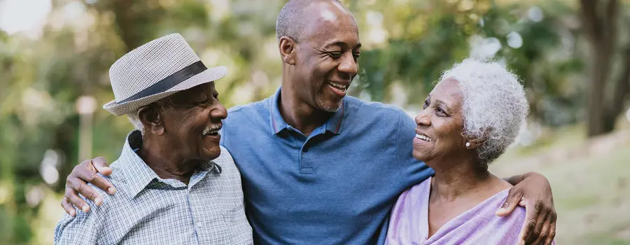 Three people hugging and smiling