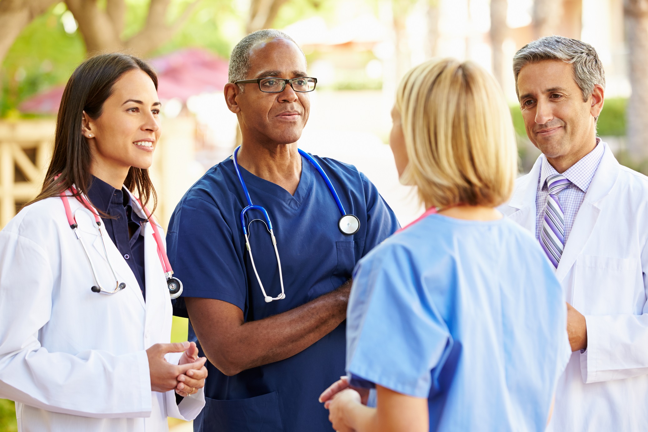 Four medical professionals speaking with each other.