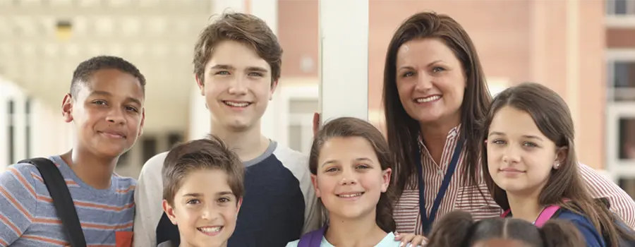 School children smiling with backpacks on