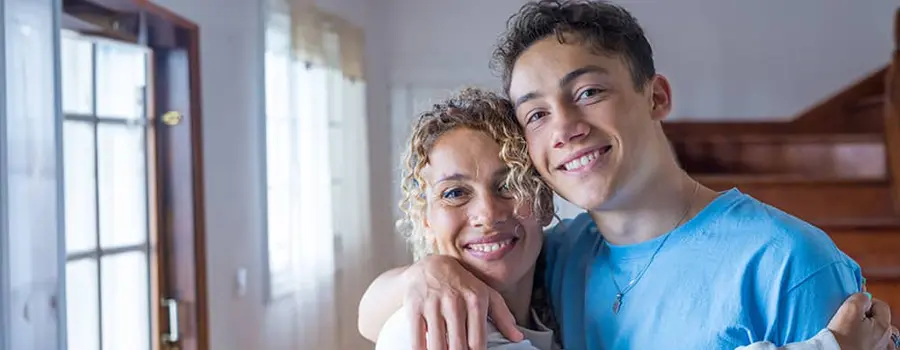 A mother and son hugging and smiling